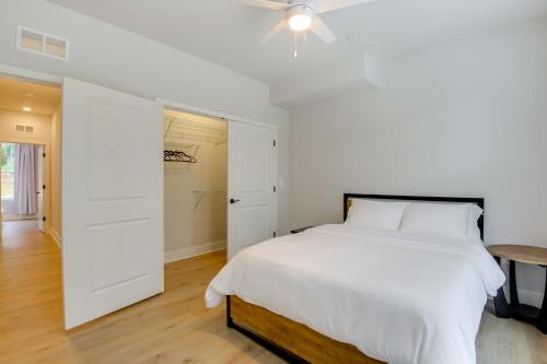 a white bedroom with a bed and a table at Modern Gem Near Historic Annapolis and Naval Academy in Annapolis