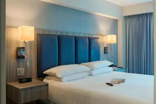 a bedroom with a large bed with a blue headboard at DoubleTree by Hilton Managua in Managua