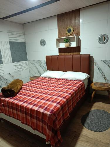 a bedroom with a bed with a checkered blanket at Hotel, Casa Calle Real in Salento