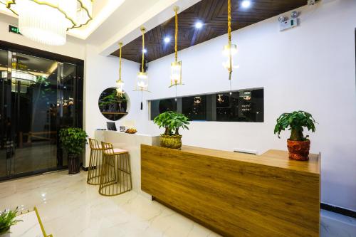 a lobby with a reception desk with potted plants at XI SHANG YUN JIAN Inn in Hanqiyu