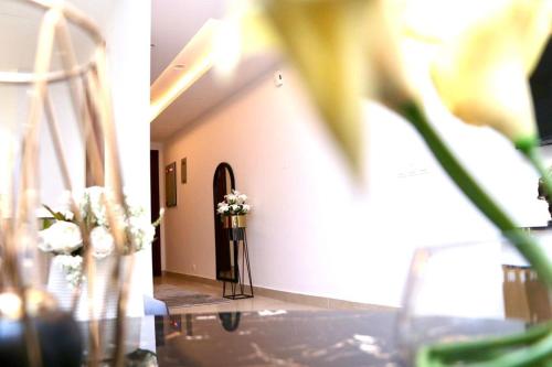 a hallway with a table with flowers in a room at Gold Crest Mall & Residency Premium Apartments With Al-Fatah Store & Shopping Mall in Lahore