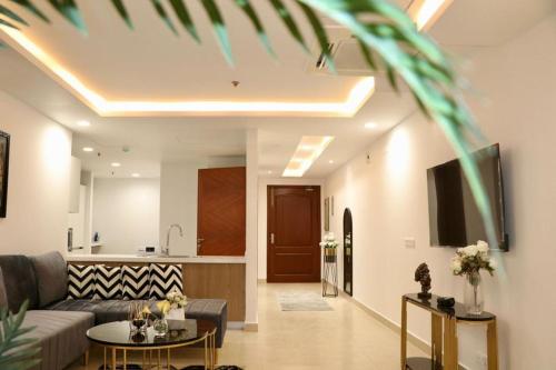 a living room with a couch and a kitchen at Gold Crest Mall & Residency Premium Apartments With Al-Fatah Store & Shopping Mall in Lahore