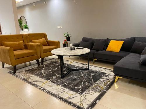 a living room with a couch and a table and chairs at Gold Crest Mall & Residency Premium Apartments With Al-Fatah Store & Shopping Mall in Lahore