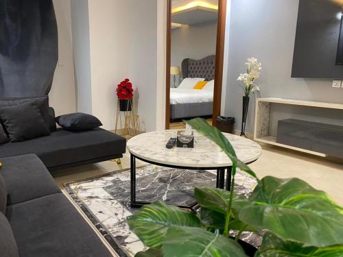 a living room with a couch and a table at Gold Crest Mall & Residency Premium Apartments With Al-Fatah Store & Shopping Mall in Lahore