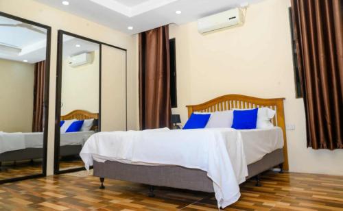 a bedroom with a bed with blue pillows and a mirror at Lautoka Home away from Home in Lautoka