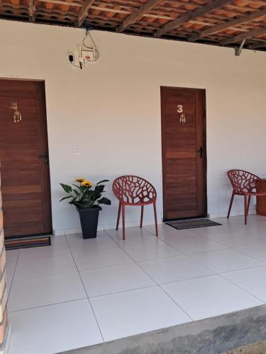 two chairs sitting in a room with two doors at Aguapé quarto 3 in Barreirinhas