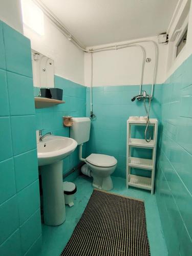 a blue bathroom with a toilet and a sink at Pura Vida Downtown Tiny houses in Bucharest