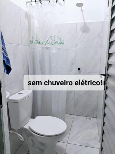 a bathroom with a toilet and a shower curtain at aguapé 1 in Barreirinhas