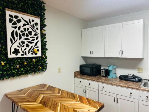 a kitchen with white cabinets and a wooden bench at Bee Happy Sparta Mountain Cottage in Sparta