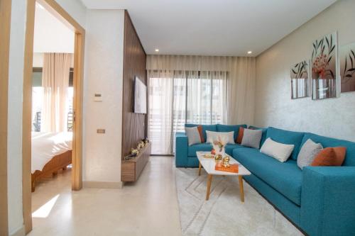 a living room with a blue couch and a bed at Studio élégant et neuf près de la gare tgv in Casablanca