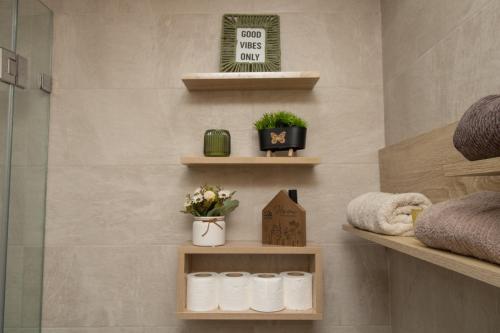 a bathroom with towels and plants on shelves at Studio élégant et neuf près de la gare tgv in Casablanca