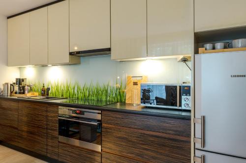 a kitchen with wooden cabinets and stainless steel appliances at BATOREGO FLATS No 13 Pszczyna - Walk to Castle - Apartment with Parking, Balcony, Elevator, Fast WiFi in Pszczyna