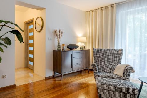 a living room with a chair and a dresser at BATOREGO FLATS No 13 Pszczyna - Walk to Castle - Apartment with Parking, Balcony, Elevator, Fast WiFi in Pszczyna