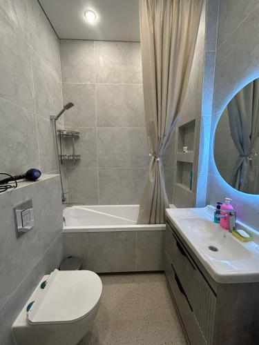 a bathroom with a toilet and a tub and a sink at Perfect HoLiDaY in Almaty