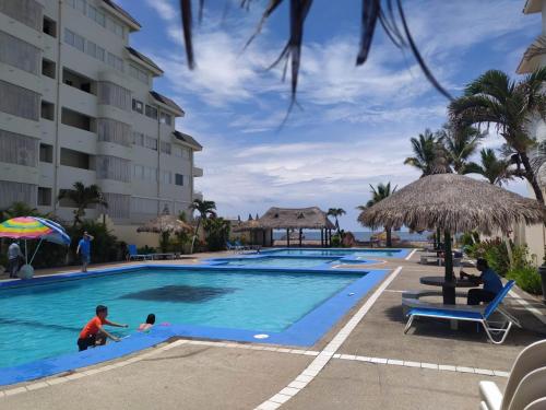 Una piscina en el complejo con gente jugando en ella. en Villa 10, en Mazatlán