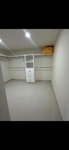 an empty kitchen with white cabinets and a white floor at Beautiful villa entire house in Plan Libertador