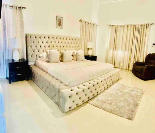 a large white bedroom with a large bed with a large headboard at Hermosa Casa familiar en las orquideas LR in La Romana