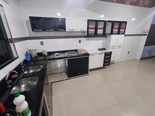 a kitchen with a sink and a stove top oven at Casa completa in Marituba