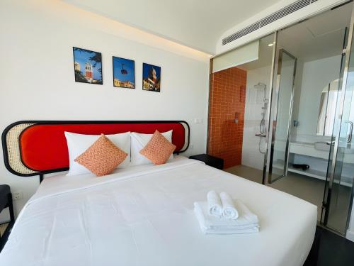 a bedroom with a white bed with two towels on it at Green Hillside Apartment in Phu Quoc