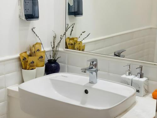 a bathroom with a white sink and a mirror at Green Hillside Apartment in Phu Quoc