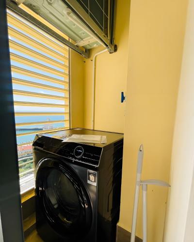 a washing machine in a room with a window at Green Hillside Apartment in Phu Quoc
