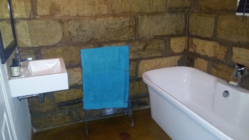 a bathroom with a bath tub and a sink at Blarney Stone Cottage in Killarney