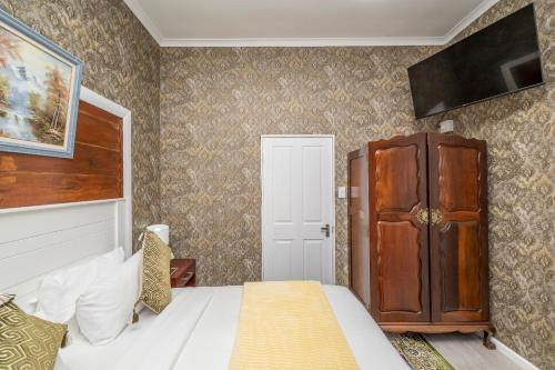a bedroom with a bed and a tv on the wall at Prime Executive Accommodation in Cape Town