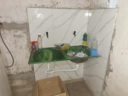 ein Badezimmer mit einem grünen Waschbecken und einem Spiegel in der Unterkunft Alex in Castanhal