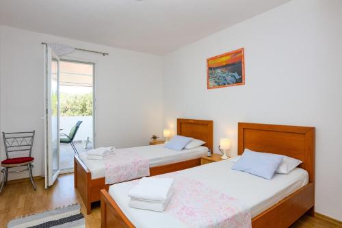 ein Schlafzimmer mit zwei Betten und einem Balkon in der Unterkunft Apartments with parking space Razanj, Rogoznica - 17328 in Rogoznica