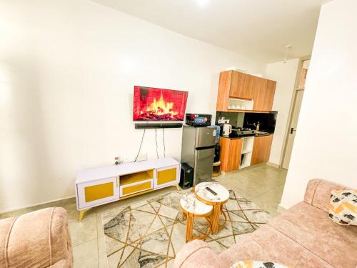 een woonkamer met een tv aan de muur bij tsavo roysambu in Nairobi