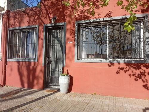 un edificio rosa con una porta e una pianta davanti di La casita de Tomi a Colonia del Sacramento