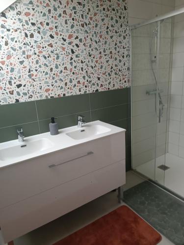 a bathroom with a white sink and a shower at Entre terre et mer in Val Couesnon