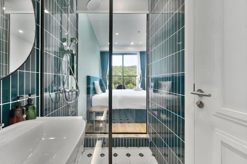 a bathroom with a tub and a bedroom at Green Hillside Apartment in Phu Quoc