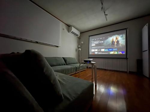 a living room with a couch and a big screen tv at SEA EIRENE Hillstop Onnason in Inbu