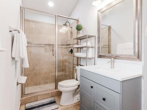 Un baño con inodoro, lavabo y ducha. en Downtown Vibes - 5 Min to City Core, en Dallas