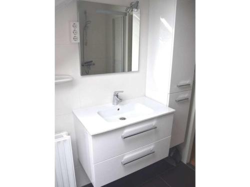 a white bathroom with a sink and a mirror at Holiday home in Breskens with Wi-Fi in Breskens