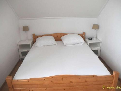a bedroom with a wooden bed with two night stands at Holiday home in Breskens with Wi-Fi in Breskens