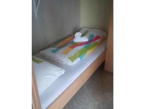 a small bed in a small room with at Hut in Baarland with swimming pool in Baarland
