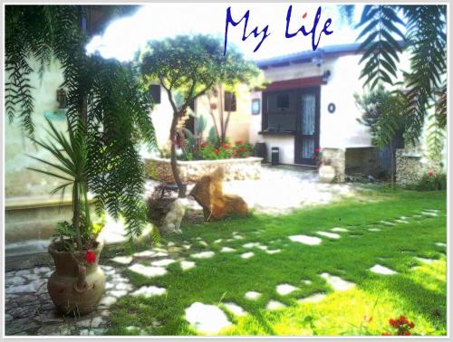 a yard with plants and a house with the words my life at MyLife B&B Country House in Castellaneta Marina 