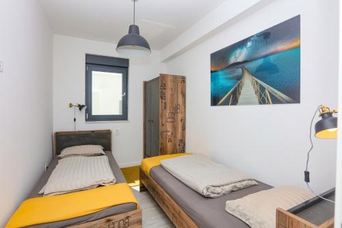 ein Schlafzimmer mit zwei Betten und einem Gemälde an der Wand in der Unterkunft Family-friendly apartments with swimming pool Murter - 22942 in Murter