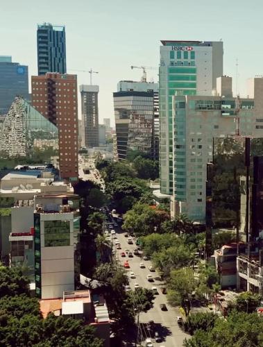 a city street with cars in a city with tall buildings at Dhaus Country Club in Guadalajara