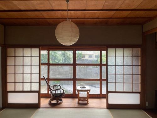 a room with a chair and a large window at MYOJI HOUSE 2 Traditional Japanese Stay in Katsuragi