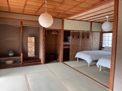 a bedroom with a bed and a room with a bed sqor at MYOJI HOUSE 2 Traditional Japanese Stay in Katsuragi