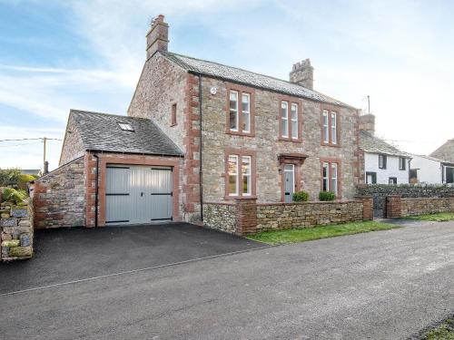a brick house with a garage in front of it at The Laburnums in Askham