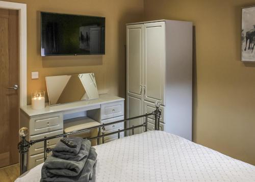 a bedroom with a bed and a dresser with a mirror at Beech Tree Park Cottages in Hatfield