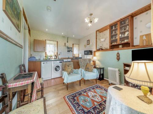 a kitchen and living room with a table and chairs at The Bothy - Uk37414 in Bunessan
