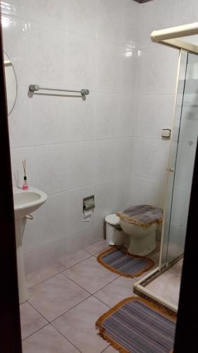 a bathroom with a toilet and a sink at Pousada Angelical in Saquarema
