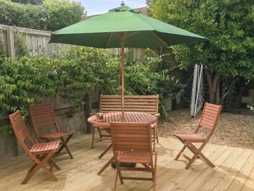 a table and chairs with an umbrella on a patio at Greenridge in Totland