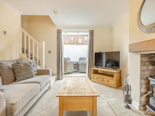 a living room with a couch and a tv and a table at The Malt House- Uk34817 in Tattershall