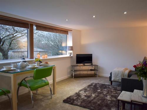 a living room with a table and a television at Uphempston Farm House Annex in Totnes